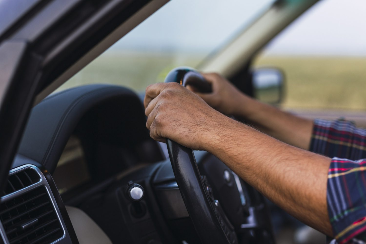 closeup-shot-hands-person-steering-wheel-modern-car closeup-shot-hands-person-steering-wheel-modern-car